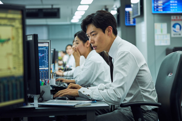 영화 돈(2019)의 한 장면. 브로커로 등장하는 류준열이 컴퓨터를 보고 있다.
